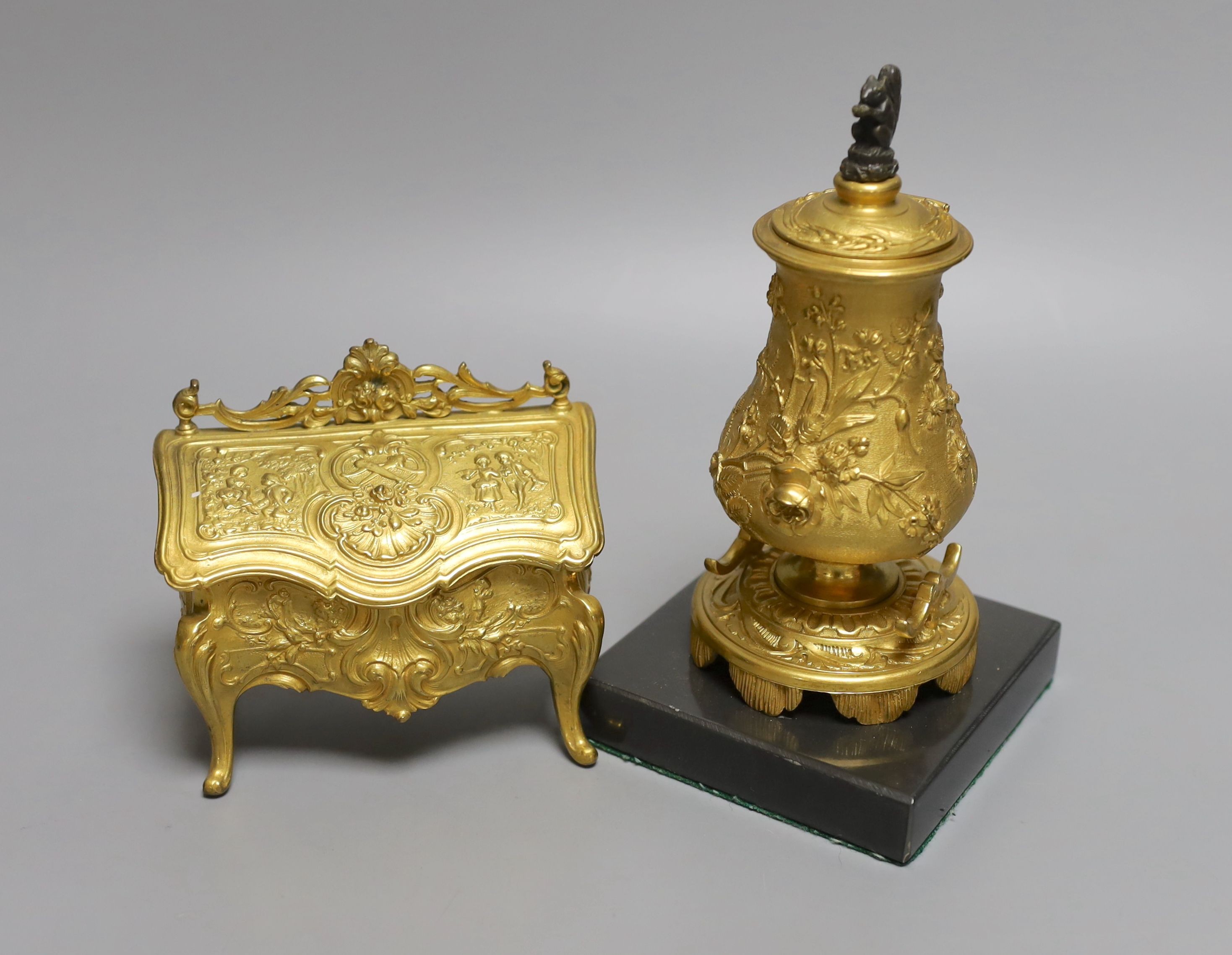 A novelty gilt metal, serpentine shaped miniature chest inkwell and a similar urn shaped inkwell, Chest 11 cms wide.